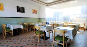 Un restaurante con mesas y sillas en una sala. en GreenTree Inn Fuzhou Gulou District West Xierhuan Road Zuohai Park, en Fuzhou