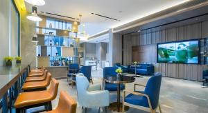 eine Lobby mit Stühlen und einem TV in einem Gebäude in der Unterkunft Echarm Hotel Wuxi Zhongnan Road Ancient Canal in Wuxi