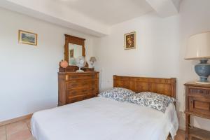ein Schlafzimmer mit einem weißen Bett und einer Holzkommode in der Unterkunft L'amourié 1er étage pour 5pers in Sainte-Croix-de-Verdon