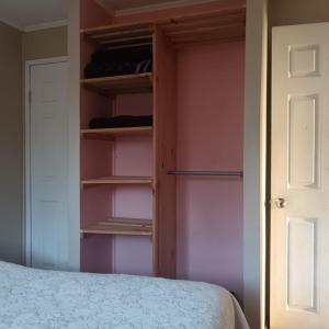 a bedroom with a bed and a closet with shelves at Base Rebelde 77 in Quilpué