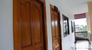 a room with a wooden door and a balcony at N-Joy Place in Surin
