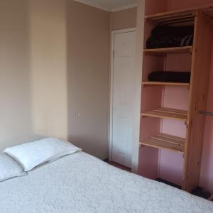 a bedroom with a bed and an open closet at Base Rebelde 77 in Quilpué