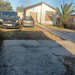 a driveway with two cars parked in front of a house at Base Rebelde 77 in Quilpué