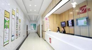 two women are sitting at a counter in a store at Shell Taiyuan South Station Shanxi University Hotel in Taiyuan