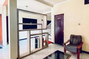 a living room with a chair and a window at RedDoorz Syariah near T1 Juanda Airport 2 in Surabaya