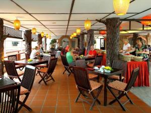a restaurant with tables and chairs and people eating at Hoi An Lantern Hotel in Hoi An