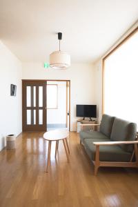 un soggiorno con un divano e un tavolo di Mother River Stays -Stream Inn Shibetsu- Vacation Home, Gateway to Shiretoko & Nemuro Strait a Shibetsu