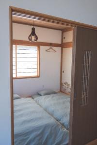 una camera da letto con due letti e una finestra di Mother River Stays -Stream Inn Shibetsu- Vacation Home, Gateway to Shiretoko & Nemuro Strait a Shibetsu
