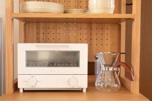 a kitchen with a microwave and a blender on a shelf at Mother River Stays -Stream Inn Shibetsu Honioi- Gateway to Shiretoko & Notsuke in Shibetsu