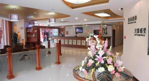 a lobby with a flower arrangement in a room at GreenTree Inn Taicang Baolong Square Hotel in Taicang