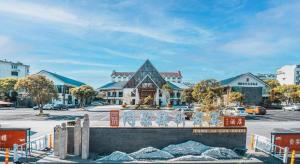 a building with a mural on it in a parking lot at Huangshan Shuguang Yusong Hotel in Huangshan