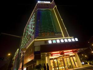 een hoog gebouw met 's nachts verlichting bij GreenTree Inn Fuzhou Dongxiang Longshan Express Hotel in Dongxiang