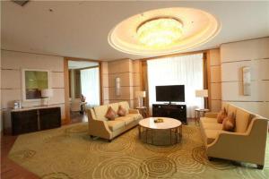 a large living room with two chairs and a table at Dusit D2 Binhu Changzhou Hotel in Changzhou