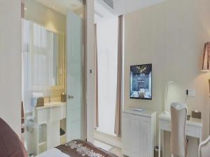 Una habitación blanca con una cama y un espejo. en Changshu Please Hotel, en Changshu