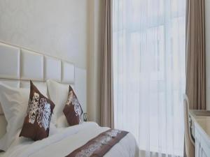 Un dormitorio con una cama con almohadas y una ventana. en Changshu Please Hotel, en Changshu 34 fotos más