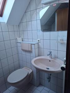 Un baño blanco con inodoro y lavabo. en Gästezimmer Hagenschieß, en Pforzheim 24 fotos más