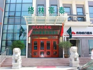 a building with two white statues in front of it at GreenTree Inn Xuzhou High Speed Railway Station Express Hotel in Xuzhou