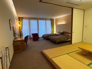 a hotel room with a bed and a mirror at Jibuzaka Village Hotel in Achi