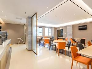 een eetkamer met tafels en stoelen en een spiegel bij City Comfort Inn Beiliu Bus Terminal in Beiliu