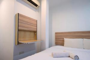 Un dormitorio con una cama blanca con cabecero de madera. en T Hotel Kuala Perlis, en Kuala Perlis