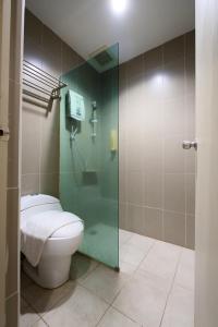 Un baño con inodoro y cabina de ducha de cristal. en T Hotel Kuala Perlis, en Kuala Perlis
