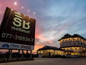 a large building with a sign in front of it at The Rich Residence in Ban Tha Kup