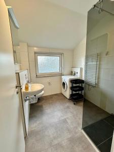 ein Badezimmer mit Waschbecken und Waschmaschine in der Unterkunft Strandnahe Ferienwohnung Nordsee Oase Whg. 1 in Cuxhaven