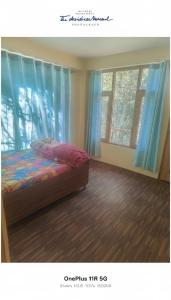 a bedroom with a bed with blue curtains at Rangoli cafe and home stay in Vashisht