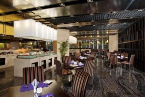 un restaurant avec des tables et des chaises et une cuisine dans l'établissement Holiday Inn Xi'an Greenland Century City By IHG, à Xi'an