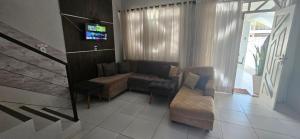 Una sala de estar con un sofá y un televisor. en Casa cinza em frente à praia em condominio, en Aracaju
