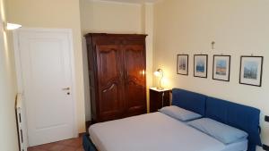 a bedroom with a blue bed and a wooden cabinet at Federico II in Brindisi