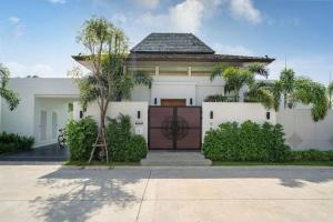 a white house with a gate and palm trees at Escape Villa in Ban Bang Khu