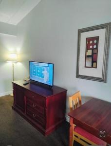 Una sala de estar con un televisor sobre una cómoda de madera. en Niagara Best Inn, en Niagara Falls