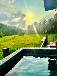 a swimming pool with a view of a field at Calm Side Villa Hikkaduwa in Hikkaduwa