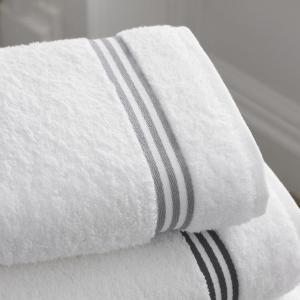 a stack of white towels with black stripes at OYO 228 Sea View Hotel in Colombo