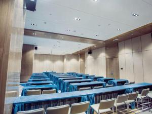 a large room with blue tables and chairs at Echarm Hotel Qionghai Wanquan River in Qionghai