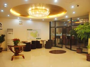 a lobby with a table and chairs and a chandelier at GreenTree Inn Chaoyang Shuangta District Bus Station in Chaoyang