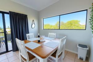 Un comedor con mesa y sillas de madera. en Steps from The Strand 2bed 2bath Riveria Retreat Pool & Castle Hill Views in Townsville, en North Ward