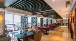 ein Restaurant mit Tischen und Stühlen und Fenstern in der Unterkunft SSAW Boutique Hotel Shaoxing Ancient Town in Dongpu