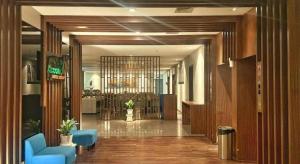 een lobby met blauwe stoelen in een gebouw bij Indies Style Hotel Bandung in Bandung