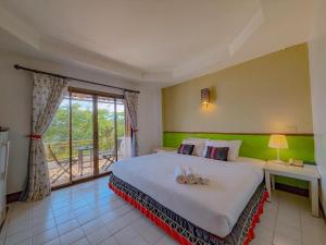 ein Schlafzimmer mit großem Bett und Balkon in der Unterkunft Phumanee Home Hotel in Fang