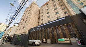 een gebouw met een bord ervoor bij Hotel J Suwon in Suwŏn-yŏk