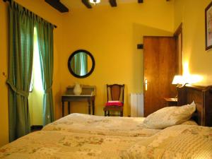 um quarto com uma cama, um espelho e uma cadeira em Casa Rural Petisansenea II em Zuaztoy de Azpilcueta