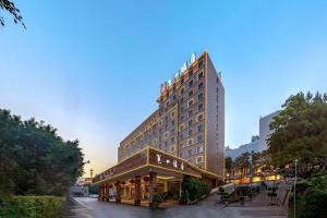 a tall building with a restaurant in front of it at Nanning Yongzhou Hotel in Nanning