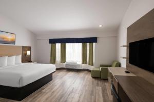 a hotel room with a bed and a flat screen tv at Days Inn by Wyndham Monterey Downtown in Monterey