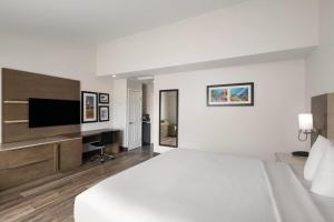 a hotel room with a bed and a flat screen tv at Days Inn by Wyndham Monterey Downtown in Monterey