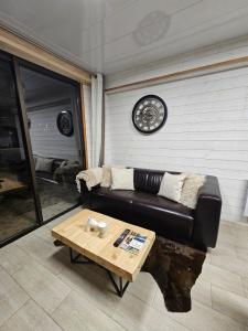 ein Wohnzimmer mit Ledersofa und Couchtisch in der Unterkunft Chalet Alpha in Les Angles