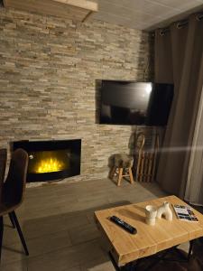ein Wohnzimmer mit Kamin und Fernseher in der Unterkunft Chalet Alpha in Les Angles