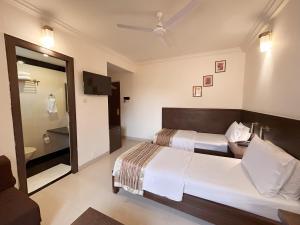 Postel nebo postele na pokoji v ubytování Hotel Aroma Executive Panaji -Stay in the Heart of the City + 17 fotografií