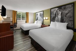 una habitación de hotel con dos camas y un escritorio en Super 8 by Wyndham Winona MN, en Winona 36 fotos más